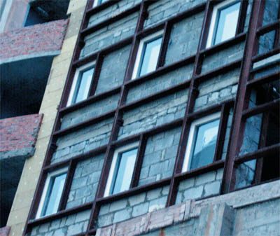 Стена здания, подготовленная для монтажа вентилируемого фасада. Оконные проемы «обрамлены» стальными швеллерами